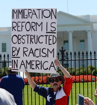 Texan holds immigration reforn sign denouncing racism at White House