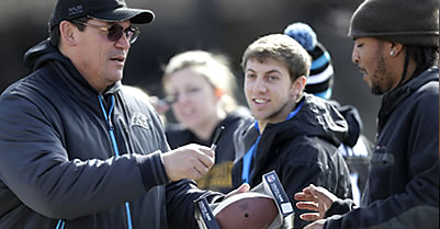 Head coach Ron Rivera signs Latino Carolina Panthers fan's football